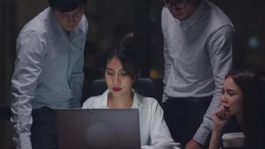 多文化商人合作进程使用笔记本电脑演示和交流会就新同事在夜间办公室的工作计划成功策略集思广益